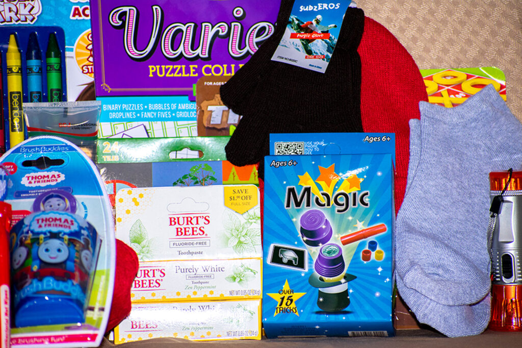 Assorted items including puzzles, crayons, socks, magic tricks, toothpaste, and a toy featuring Thomas the Tank Engine.