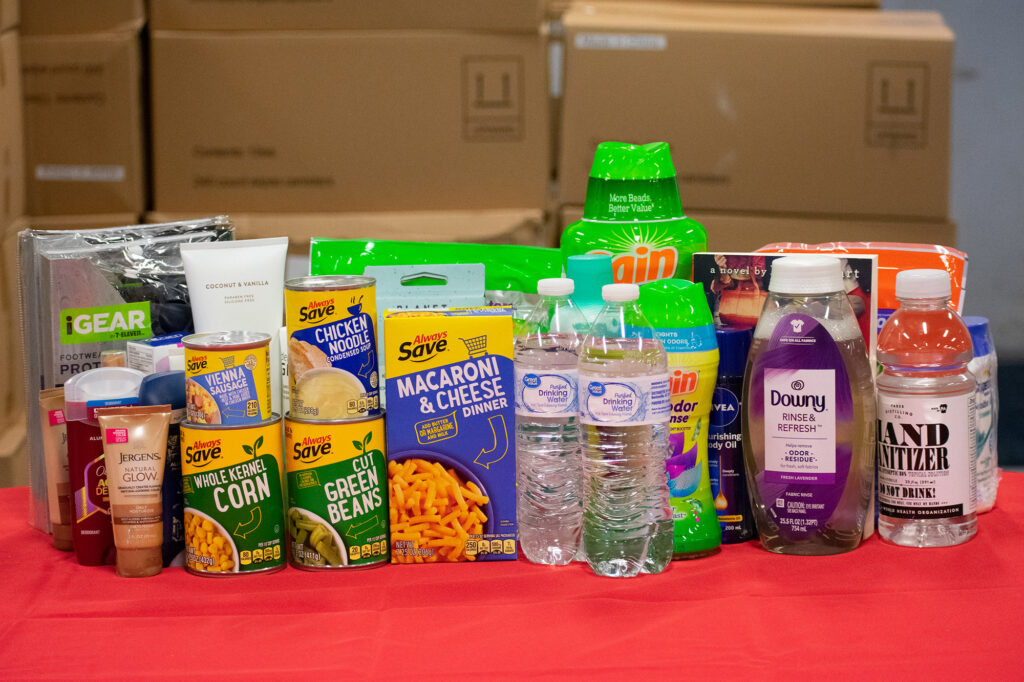 A variety of food items, beverages, and personal care products are displayed on a table. Northern Plains Reservation Aid is appropriate.
