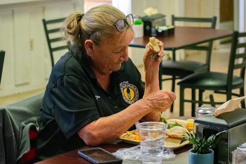 A person is sitting at a table eating a meal, possibly involved with northern plains reservation aid.