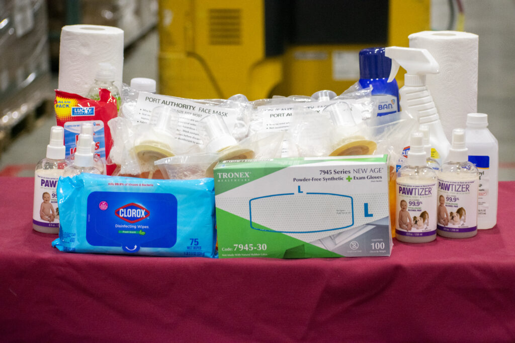 Various hygiene and cleaning supplies, including disinfecting wipes, gloves, sanitizer, face masks, and paper towels.